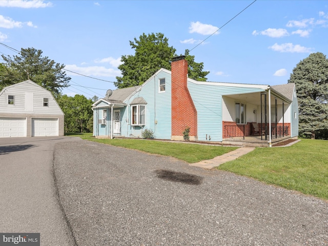 4126 Coseytown Rd, Greencastle, PA 17225 - view of front facade with an outdoor structure, a detached garage, covered porch, a front lawn, and a chimney