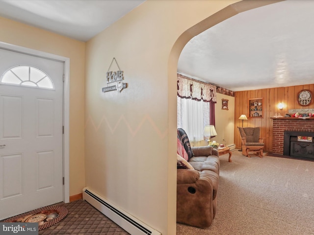 4126 Coseytown Rd, Greencastle, PA 17225 - foyer featuring a baseboard radiator, carpet flooring, arched walkways, a brick fireplace, and wood walls