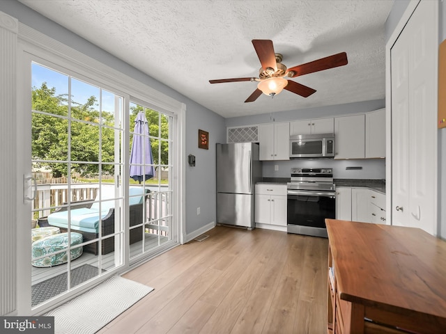 6300 Loring Dr, Columbia, MD 21045 - kitchen with appliances with stainless steel finishes, a ceiling fan, wooden counters, white cabinets, and light wood-style flooring