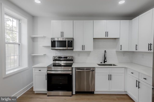 1801 Otis St NE Unit 6, Washington, DC 20018 - kitchen with stainless steel appliances, open shelves, backsplash, light countertops, and recessed lighting