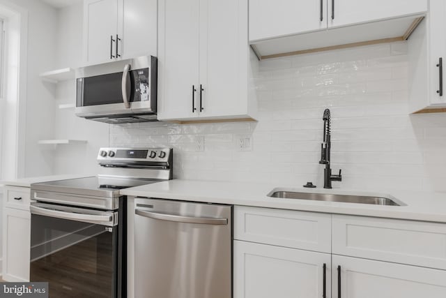 1801 Otis St NE Unit 6, Washington, DC 20018 - kitchen featuring appliances with stainless steel finishes, open shelves, light countertops, and white cabinetry