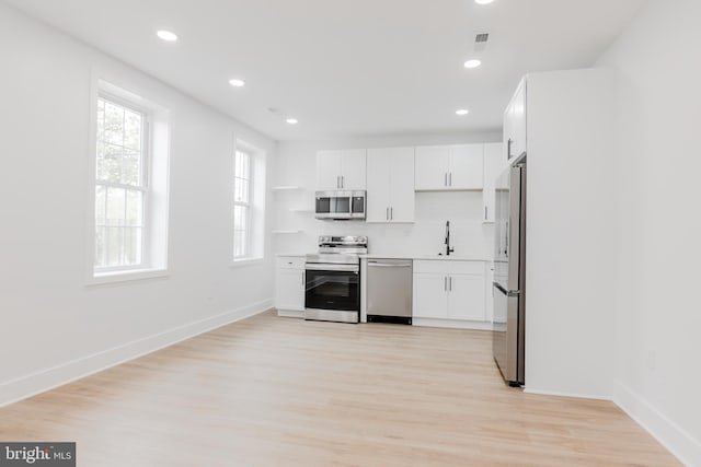 1801 Otis St NE Unit 6, Washington, DC 20018 - kitchen with appliances with stainless steel finishes, white cabinets, light wood-style flooring, light countertops, and recessed lighting