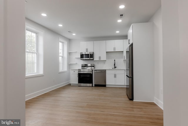 1801 Otis St NE Unit 6, Washington, DC 20018 - kitchen featuring stainless steel appliances, white cabinets, decorative backsplash, light wood-style flooring, and recessed lighting