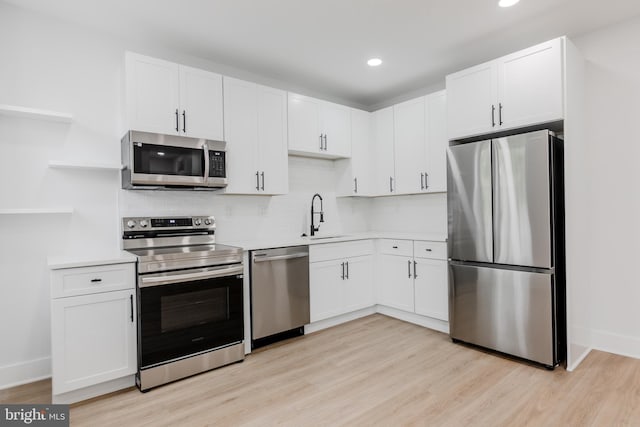1801 Otis St NE Unit 6, Washington, DC 20018 - kitchen featuring stainless steel appliances, open shelves, light wood-style flooring, light countertops, and white cabinetry