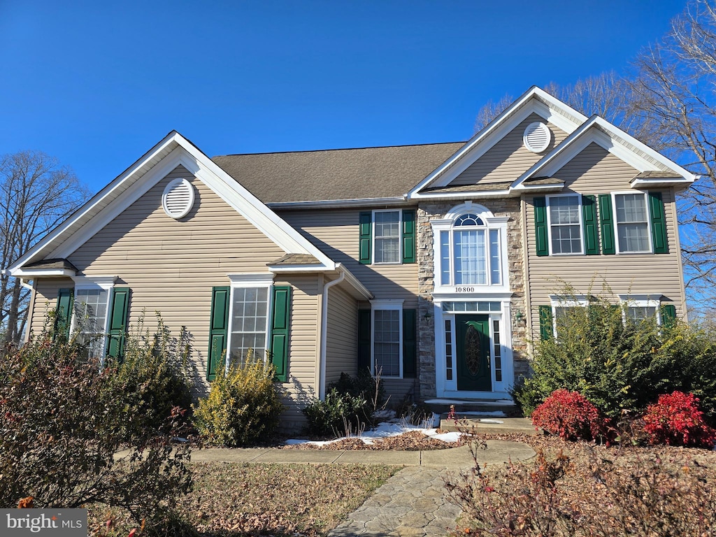 colonial house featuring stone siding