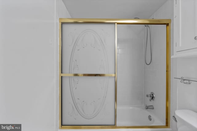 bathroom featuring shower / bath combination with glass door and toilet