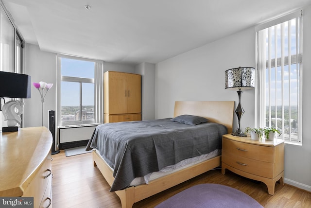 bedroom featuring light wood-style flooring and baseboards