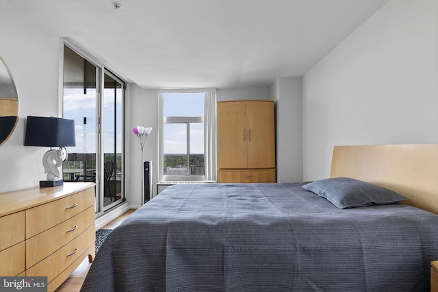 bedroom with light wood-style flooring and access to outside