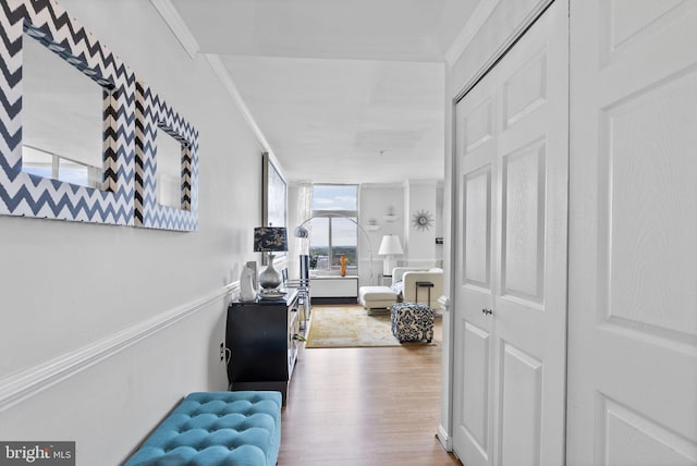 hallway featuring wood finished floors and crown molding