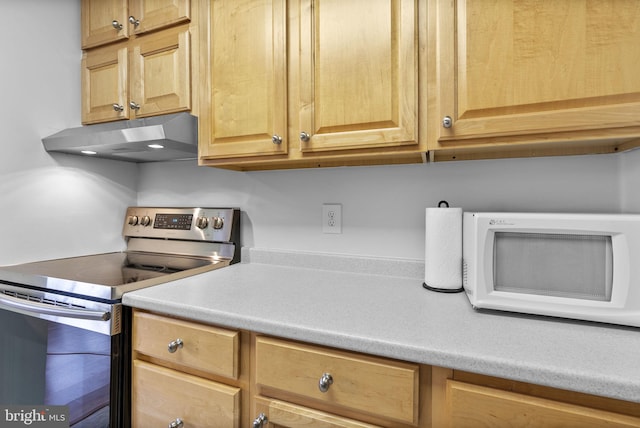 kitchen with electric range, under cabinet range hood, white microwave, and light countertops