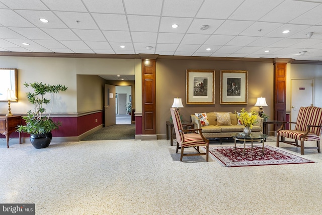 living area featuring decorative columns, ornamental molding, baseboards, and recessed lighting