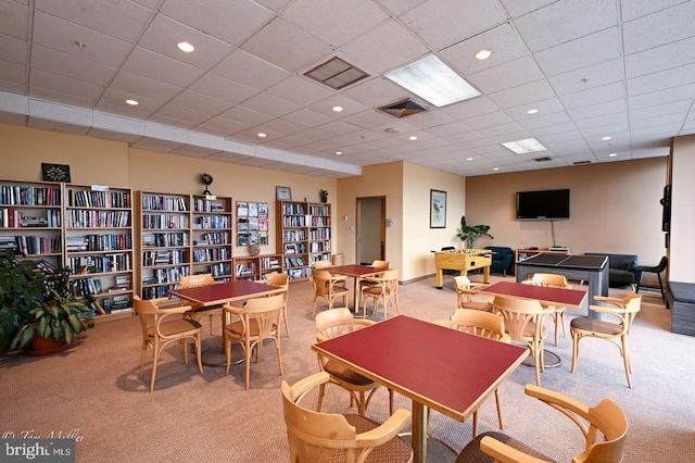 dining area featuring carpet flooring and a paneled ceiling