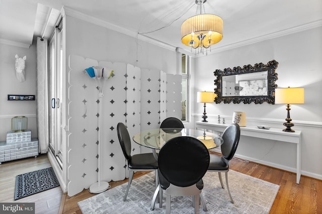dining space featuring crown molding, wood finished floors, and a chandelier