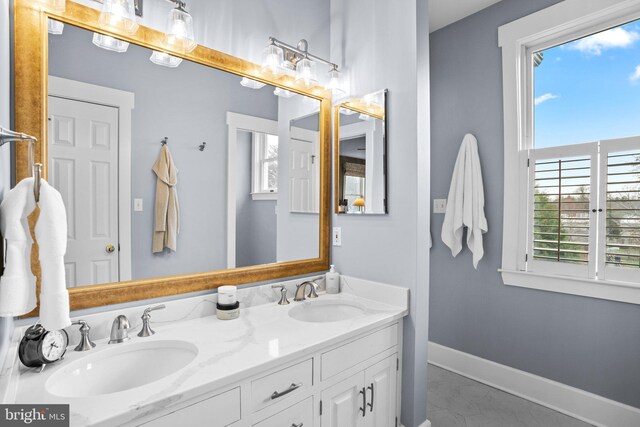 16 Glyndon Ave, Glyndon, MD 21071 - full bathroom featuring healthy amount of natural light, double vanity, baseboards, and marble look tile flooring