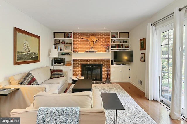 4614 Demby Dr, Fairfax, VA 22032 - living area featuring wood finished floors, a brick fireplace, built in features, and baseboards