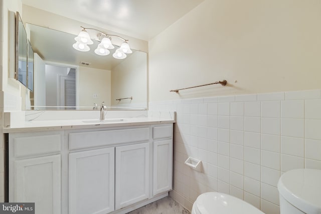 5707 Indian Ct Unit 31, Alexandria, VA 22303 - half bathroom with toilet, tile walls, vanity, marble look tiles, and a wainscoted wall