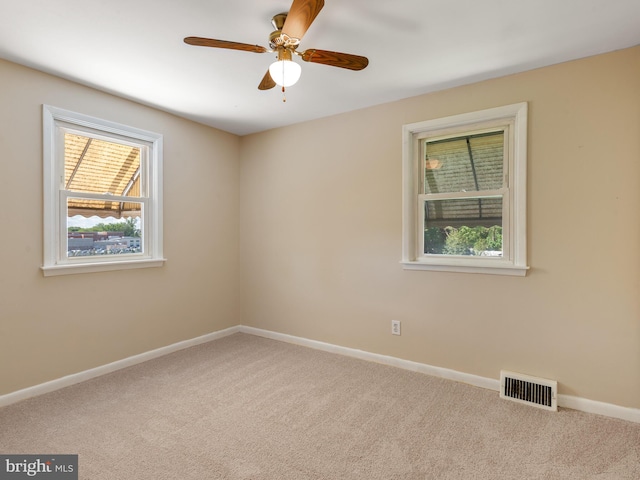 spare room with carpet, baseboards, and ceiling fan