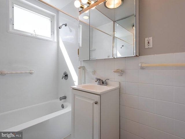 bathroom featuring bathtub / shower combination, vanity, tile walls, and decorative backsplash