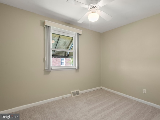 spare room with carpet, baseboards, and a ceiling fan