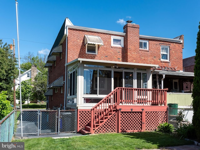 rear view of property with a sunroom, a gate, a chimney, and brick siding