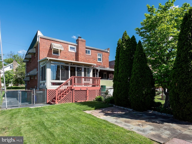 back of house featuring a chimney, brick siding, stairs, and a gate