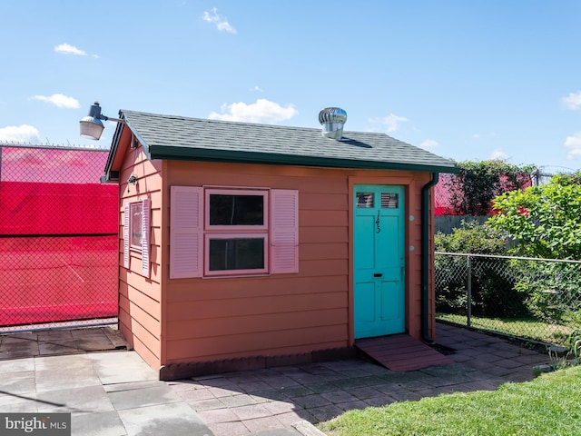 view of outdoor structure featuring fence and an outbuilding