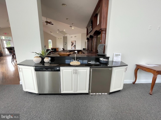 216 N Heron Ln, New Castle, DE 19720 - kitchen featuring stainless steel dishwasher, dark countertops, lofted ceiling, healthy amount of natural light, and carpet floors