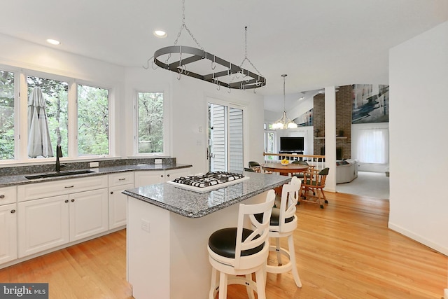 8265 Private Ln, Annandale, VA 22003 - kitchen with a sink, white gas cooktop, a center island, light wood finished floors, and open floor plan