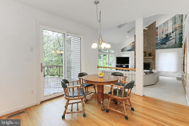 8265 Private Ln, Annandale, VA 22003 - dining area with wood finished floors, a chandelier, baseboards, vaulted ceiling, and a fireplace