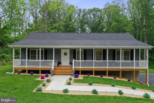 view of front of house with a porch, a front lawn, and roof with shingles