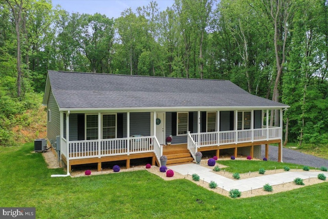 view of front of house featuring covered porch, roof with shingles, a front yard, and central AC unit