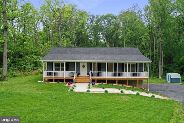 view of front facade with covered porch, a front yard, a shed, and an outdoor structure