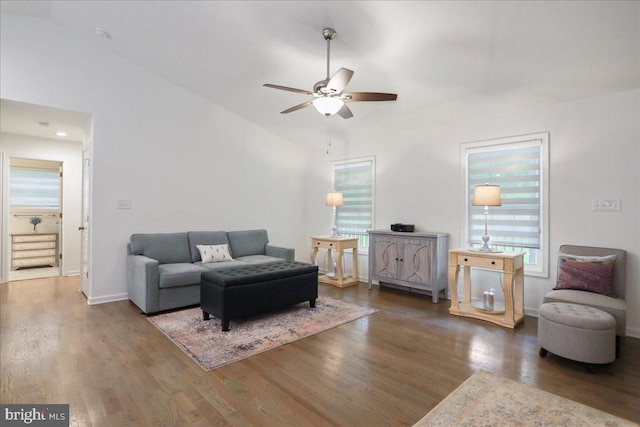 living area featuring ceiling fan, wood finished floors, vaulted ceiling, and baseboards