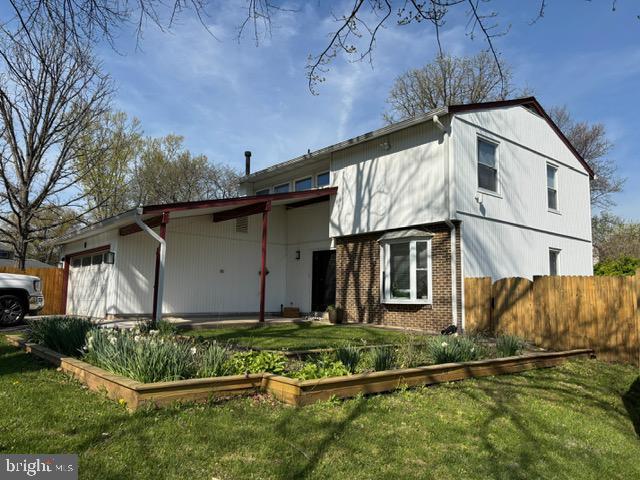 view of front of property featuring a garage, a vegetable garden, and brick siding