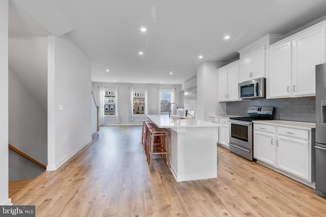 308 Bodega Ter SE, Leesburg, VA 20175 - kitchen featuring stainless steel appliances, a sink, an island with sink, white cabinetry, and light countertops