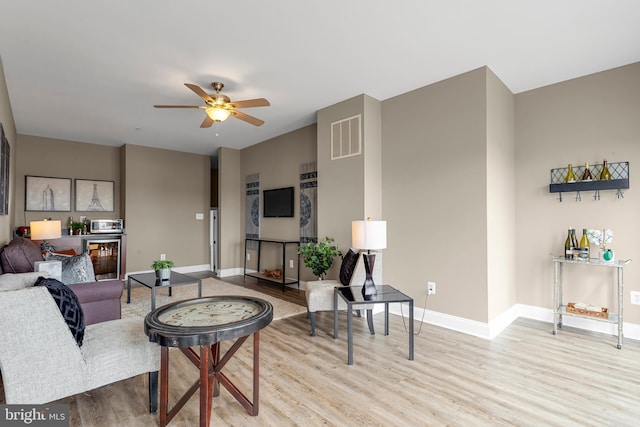 3911 Fleet St, Baltimore, MD 21224 - living room with wood finished floors, a ceiling fan, baseboards, and beverage cooler
