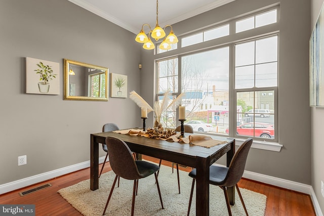 3911 Fleet St, Baltimore, MD 21224 - dining space featuring baseboards, a chandelier, healthy amount of natural light, crown molding, and wood finished floors