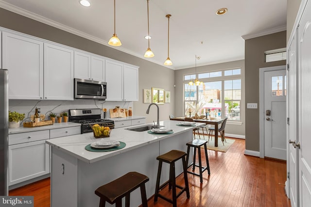 3911 Fleet St, Baltimore, MD 21224 - kitchen with stainless steel appliances, a sink, ornamental molding, white cabinetry, and dark wood-style floors