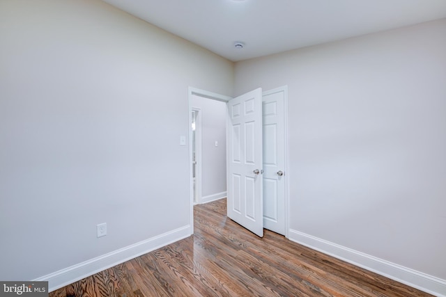 unfurnished room featuring wood finished floors and baseboards