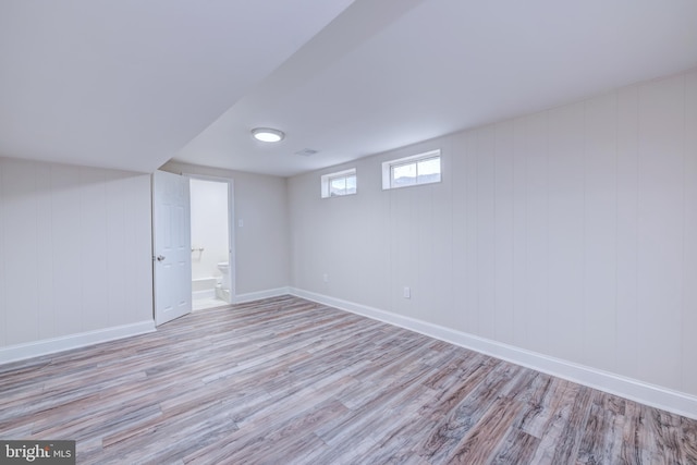 basement featuring wood finished floors and baseboards