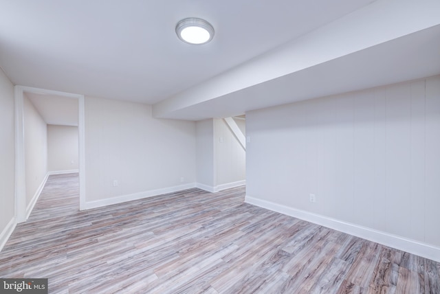 finished below grade area featuring wood finished floors and baseboards
