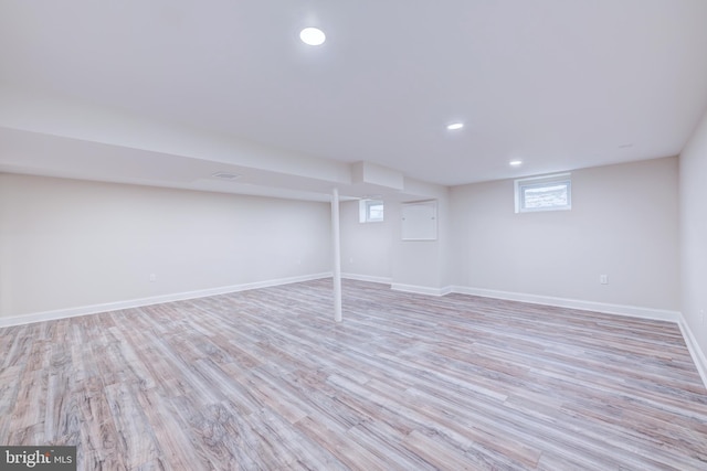 below grade area featuring recessed lighting, light wood-type flooring, and baseboards