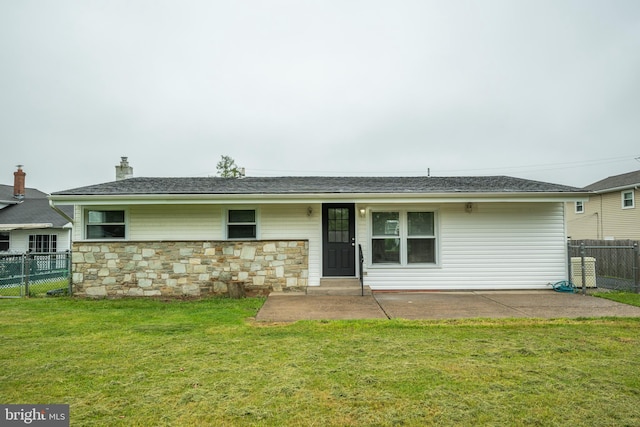 rear view of property featuring stone siding, a patio area, and a chimney