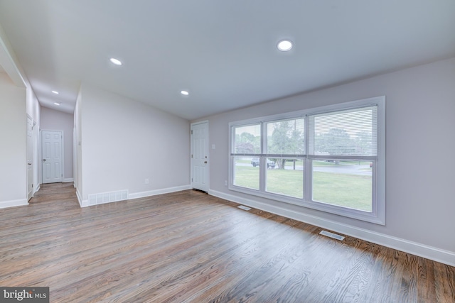 unfurnished living room featuring baseboards, wood finished floors, and recessed lighting