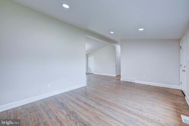spare room with recessed lighting, baseboards, and wood finished floors