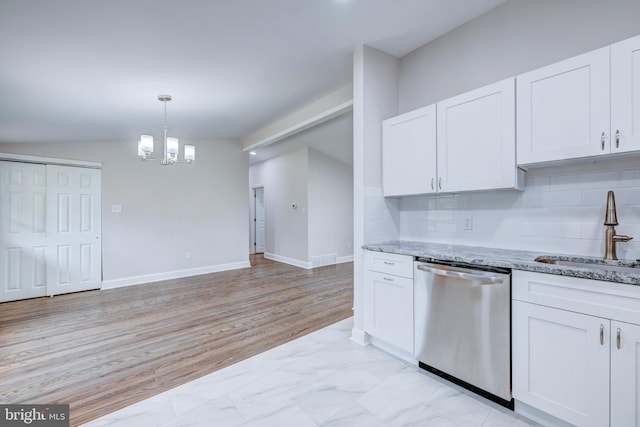 kitchen featuring dishwasher, a sink, a chandelier, white cabinetry, and light stone counters