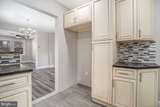 128 Linton St, Philadelphia, PA 19120 - kitchen featuring cream cabinetry, tasteful backsplash, dark stone countertops, and a chandelier