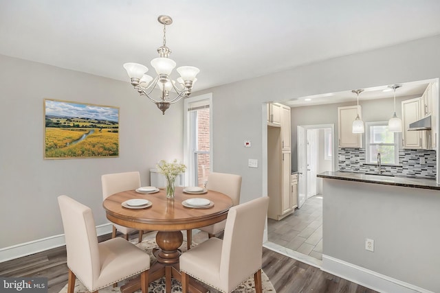 128 Linton St, Philadelphia, PA 19120 - dining space with dark wood finished floors, a chandelier, baseboards, and healthy amount of natural light