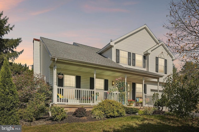 view of front of house with a porch and a shingled roof