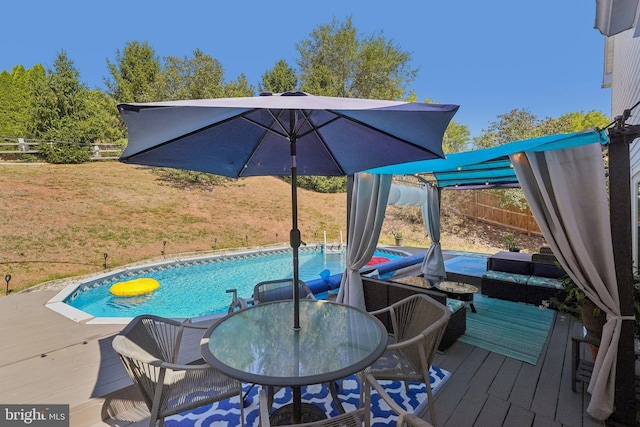 outdoor pool with a deck and outdoor dining space